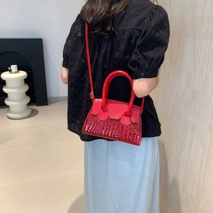Minimalist red leather crossbody bag with faux crocodile texture and gold hardware