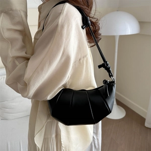 Minimalist black crescent crossbody bag with pleated design and knotted shoulder strap