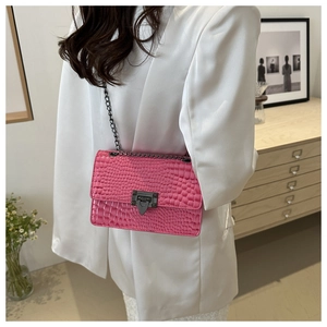 Detail of pink croc-patterned handbag with black metal chain and rivet clasp detail