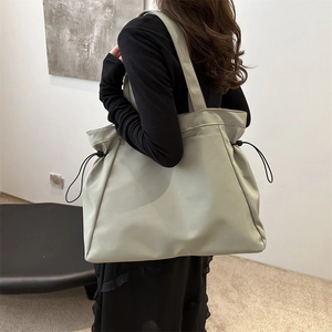 Minimalist large capacity tote bag with side drawstring detail and solid shoulder straps