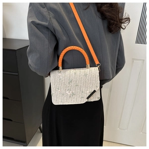 Vue détaillée du sac à main tissé avec broderies florales et poignée orange vive