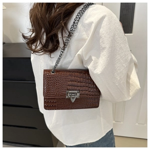 Brown crocodile pattern crossbody bag with vintage metal lock and chain strap on shoulder