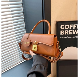 Detailed close-up of a caramel PU leather handbag with a stylish gold padlock and hangtag