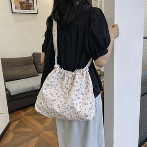Grand sac fourre-tout à fleurs beige avec cordon de serrage porté à l'épaule