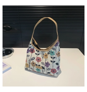 Close-up of floral tapestry tote bag with brown leather handles and woven texture details