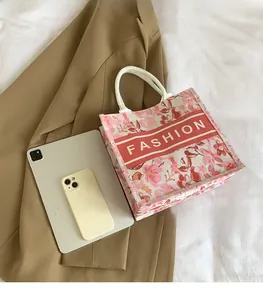 Vue à plat d'un cabas en toile fleurie avec logo FASHION à côté d'une tablette