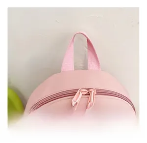 Detailed view of pink backpack top handle and smooth double zipper closure system
