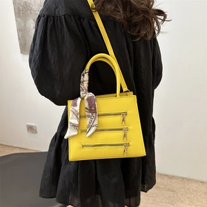 Fashionable bright yellow square crossbody bag with metal zippers and decorative scarf