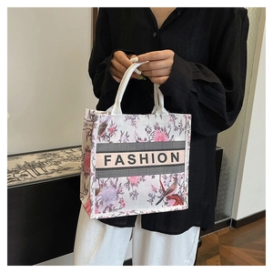 Détail du sac cabas floral avec imprimé oiseaux et ruban brodé fashion au centre