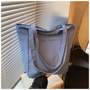 Detail view of large capacity misty blue nylon tote bag with pleated texture and handle