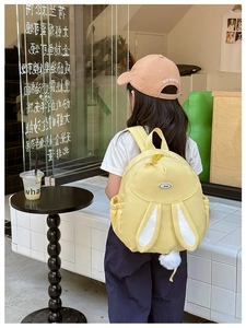 Detail of sweet yellow bunny backpack featuring long ears and white plush pom-pom tail