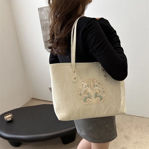 Beige tote bag with floral embroidery and gold accents for women's casual style