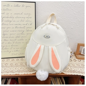 Detail of white rabbit ear backpack with soft plush tail and water-resistant nylon texture