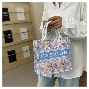 Détail du cabas floral avec motifs pied-de-poule et texte mode sur bande bleue