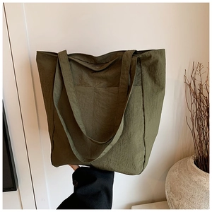 Detail of dark olive green tote bag with crinkle texture fabric and wide shoulder straps