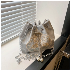 Detail der silbernen Satin-Beuteltasche mit Blumenstickerei und Perlen-Kordelzug