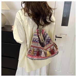 Detail of bohemian woven tote bag with geometric patterns and colorful tassels