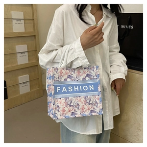 Détail du cabas en toile fleurie avec ruban mode et anses blanches tressées