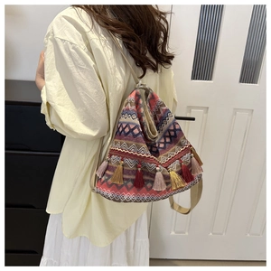 Detail view of Bohemian woven tote bag with colorful geometric patterns and tassel fringe