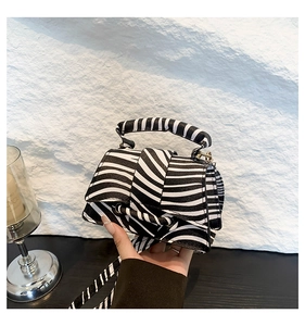 Détail du sac bandoulière zébré montrant le simili cuir texturé et la poignée carrée
