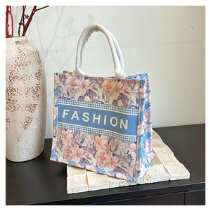 Détail du sac cabas floral avec bande bleue 'FASHION' et poignées en corde