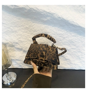 Détail du mini sac bandoulière léopard montrant le cuir texturé et la poignée