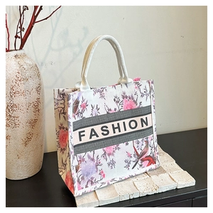 Détail du sac cabas floral avec motifs d'oiseaux et anses blanches en corde tressée