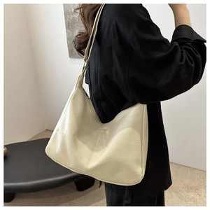 Detail of off-white large capacity tote bag with patchwork design and wide shoulder strap