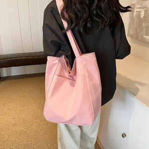 Pink canvas tote bag with shoulder straps and large capacity shown in modern interior