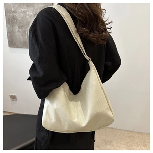 Detail of minimalist cream tote bag showing 3D geometric panel stitching on soft leather