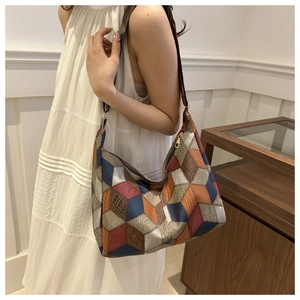 Detailed shot of large hobo bag with geometric color-block patchwork and metal zipper