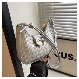 Detailed view of silver woven metallic hobo bag featuring a decorative metal bow