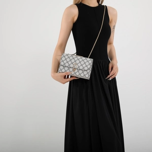 Minimalist square crossbody bag featuring black and white geometric patterns with gold chain