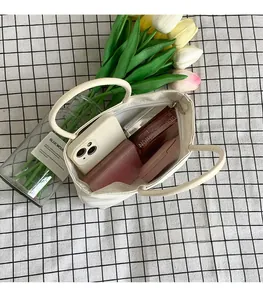 Interior detail of white bucket bag showing storage space for phone and makeup