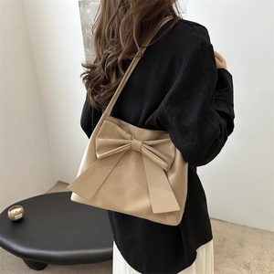 Sac fourre-tout beige minimaliste avec grand nœud porté à l'épaule pour le quotidien