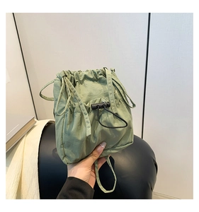 Detail of green nylon drawstring bag showing salt-shrink texture and toggle closure