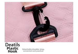 Close-up of pink quilted fabric gym bag with a black plastic hook and detachable shoulder strap