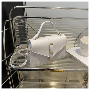 Close-up of a white textured PU leather handbag with a gold metal clasp and top handle