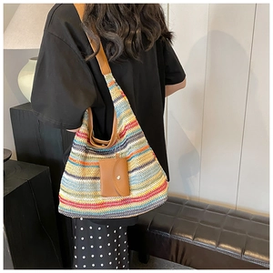 Detail of colorful striped woven tote bag with brown leather straps and mini pouch