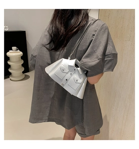 Detail view of white suit-style crossbody bag with lapel and button accents on a model