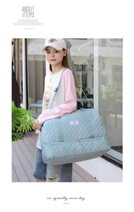 Detail view of mint green quilted travel bag with shoe compartment and adjustable strap