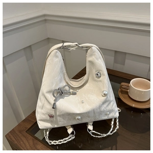 Detail of white pleated leather bag with pearls, rhinestone hearts, and chain strap