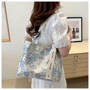 Detail of floral tote bag with blue hydrangea pattern and branded ribbon strap