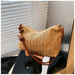 Detailed view of woven straw shoulder bag with V-shaped texture and brown knotted strap