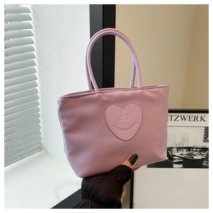 Detail of lavender nylon bucket bag featuring a heart-shaped patch and round top handles