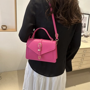 Chic rose red PU leather crossbody bag with gold buckle shown on a model in a cozy room