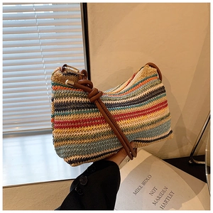 Detail of colorful striped woven shoulder bag featuring a knotted brown leather strap