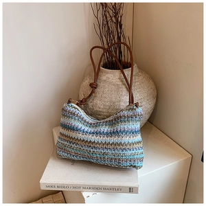 Close-up of bohemian multi-color woven shoulder bag with brown leather strap and zipper