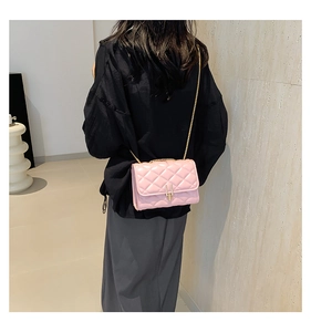 Pink quilted chain crossbody bag with gold-tone hardware on casual model look