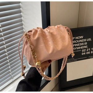 Detail of pink pleated cloud bag with golden chain strap and metallic ball hardware